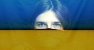 volto dietro bandiera Ucraina, conseguenze di una guerra sulla salute psicologica delle persone
