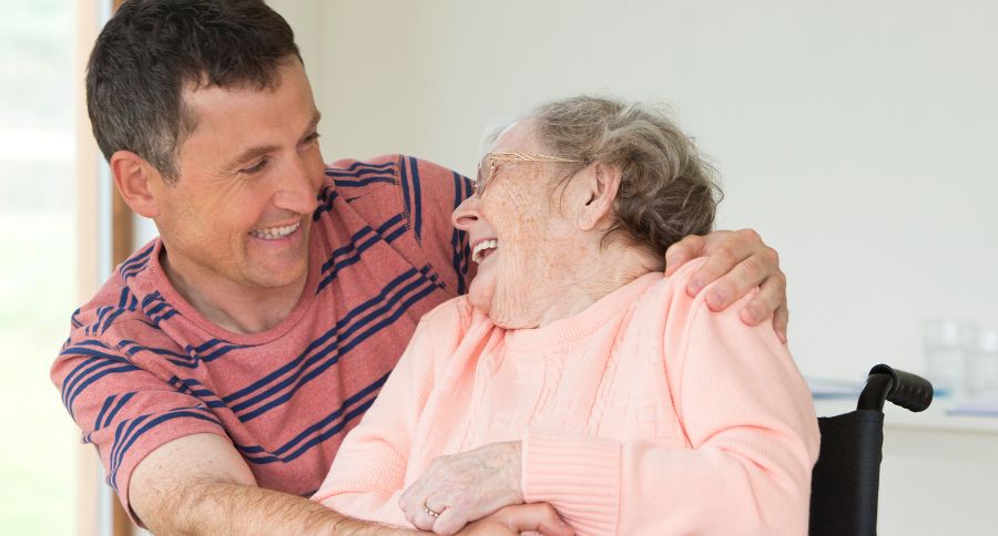 caregiving, figlio sostiene madre anziana