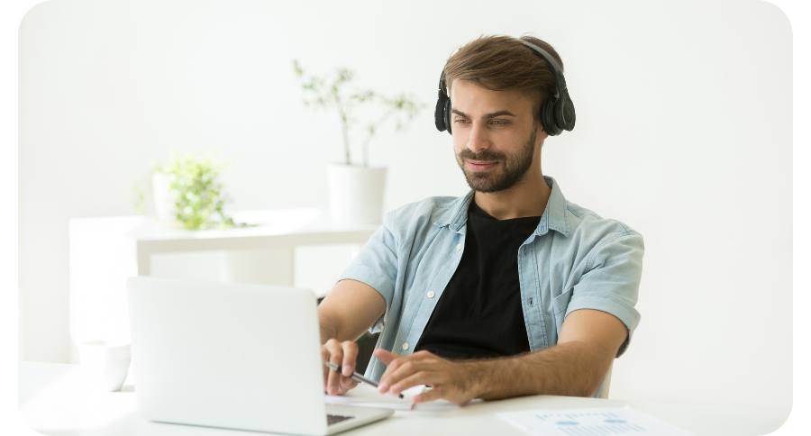 giovane uomo sereno al PC mentre ascolta musica